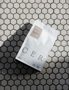 A white bag of Ceremony coffee on a tiled background. 